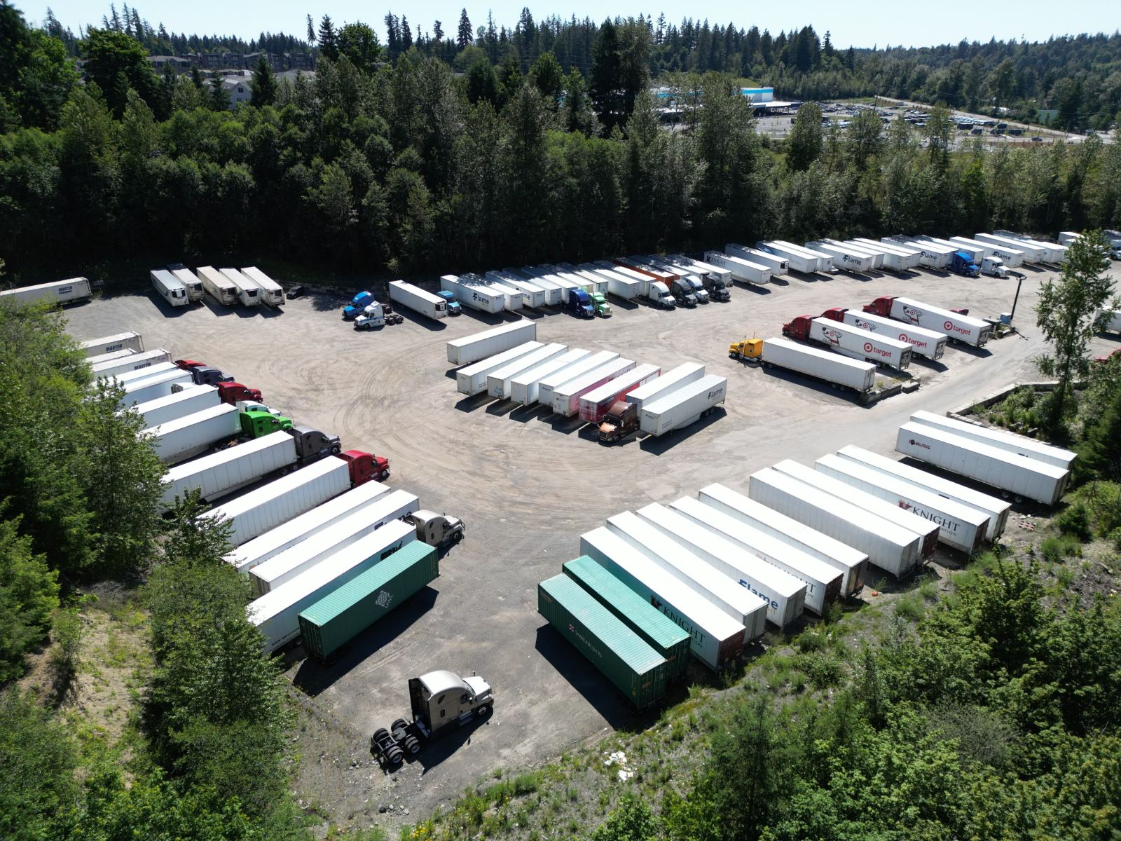Drone view of the Maple Valley yard, trailers parked around a gravel lot in the trees